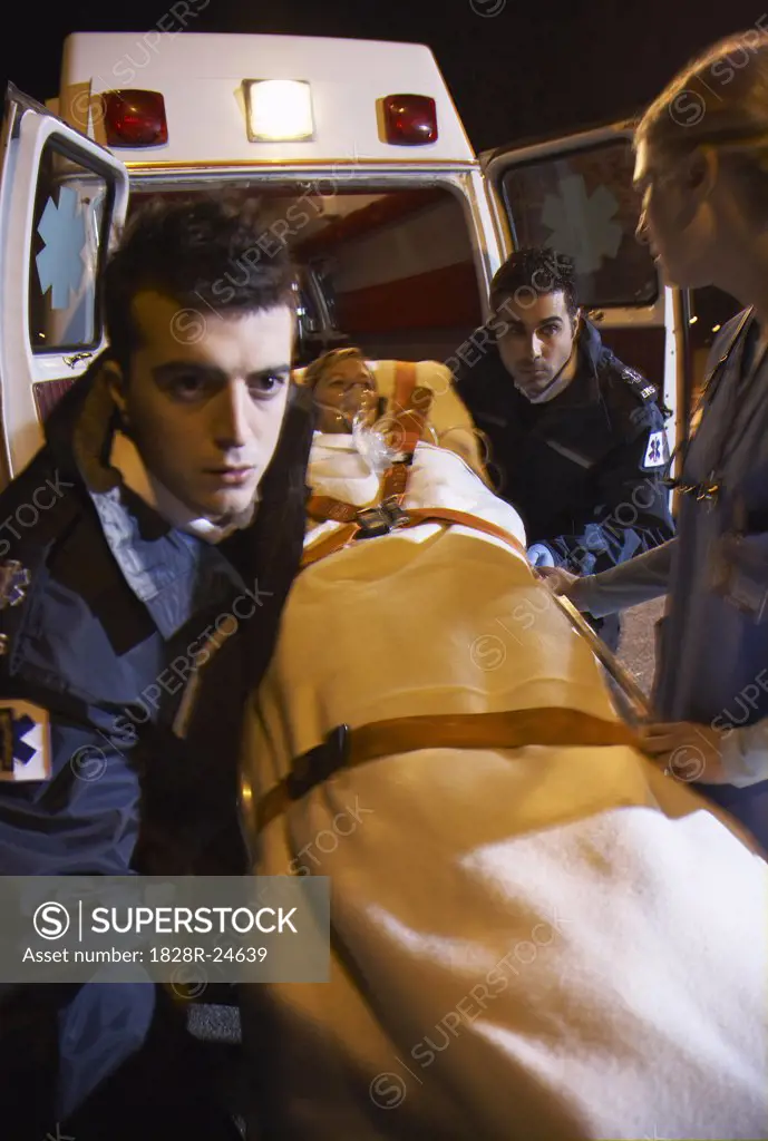 Doctor and Paramedics Removing Patient From Ambulance   