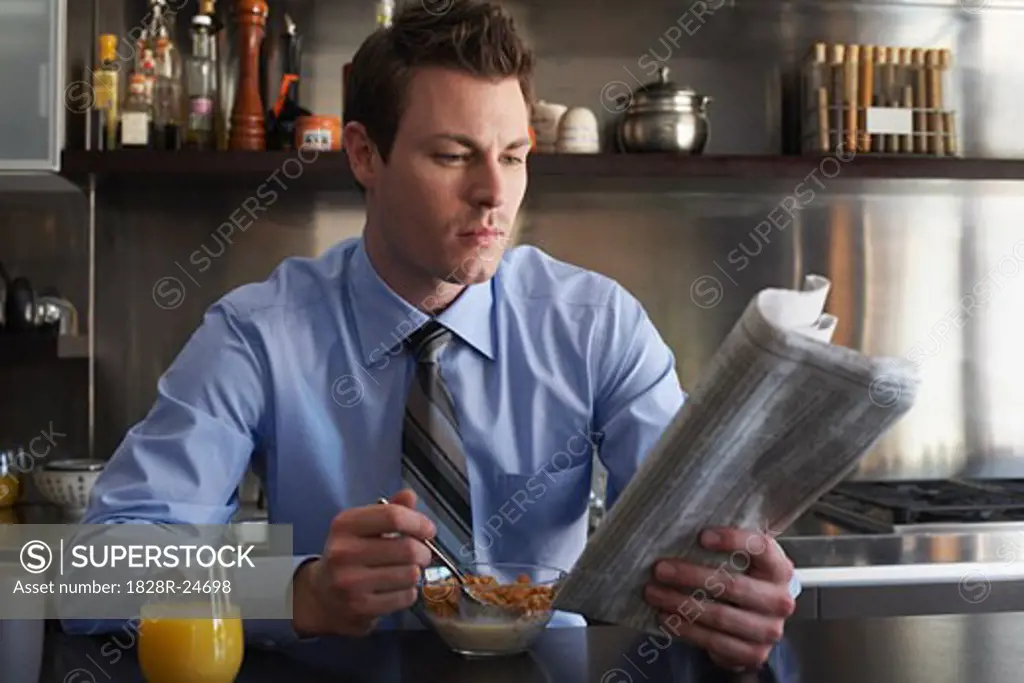 Man Reading Newspaper During Breakfast   