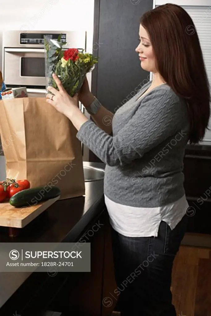 Woman Removing Groceries from Bag   