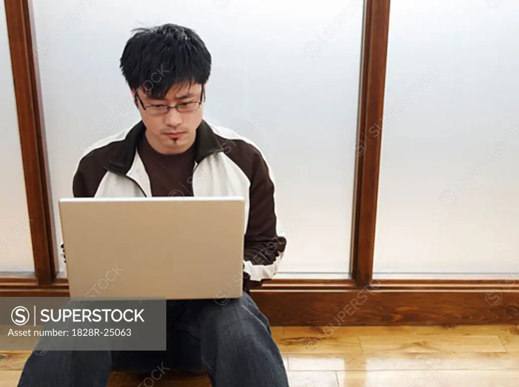 Man Sitting on Floor Using Laptop   