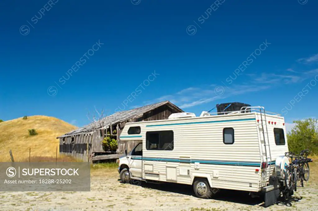 Recreational Vehicle Parked by Abandoned Building   