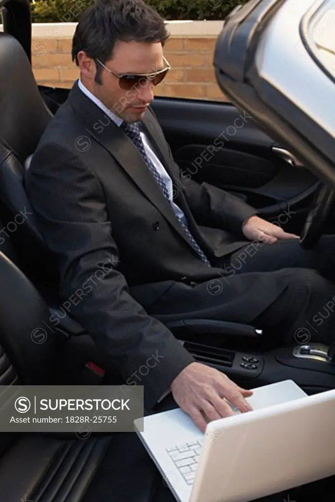 Businessman in Car with Laptop Computer   