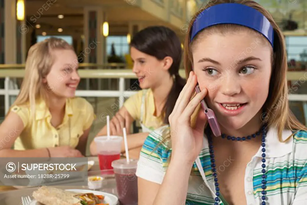 Teenager on Cell Phone with Friends in Background   