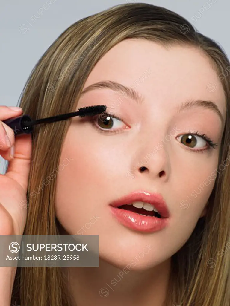 Young Woman Putting on Mascara   