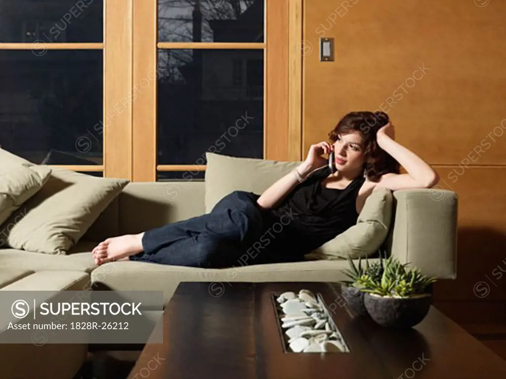 Woman Lying on Sofa, Using Cell Phone   