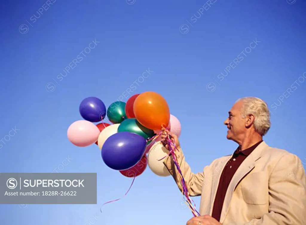 Man Holding Bunch of Balloons   