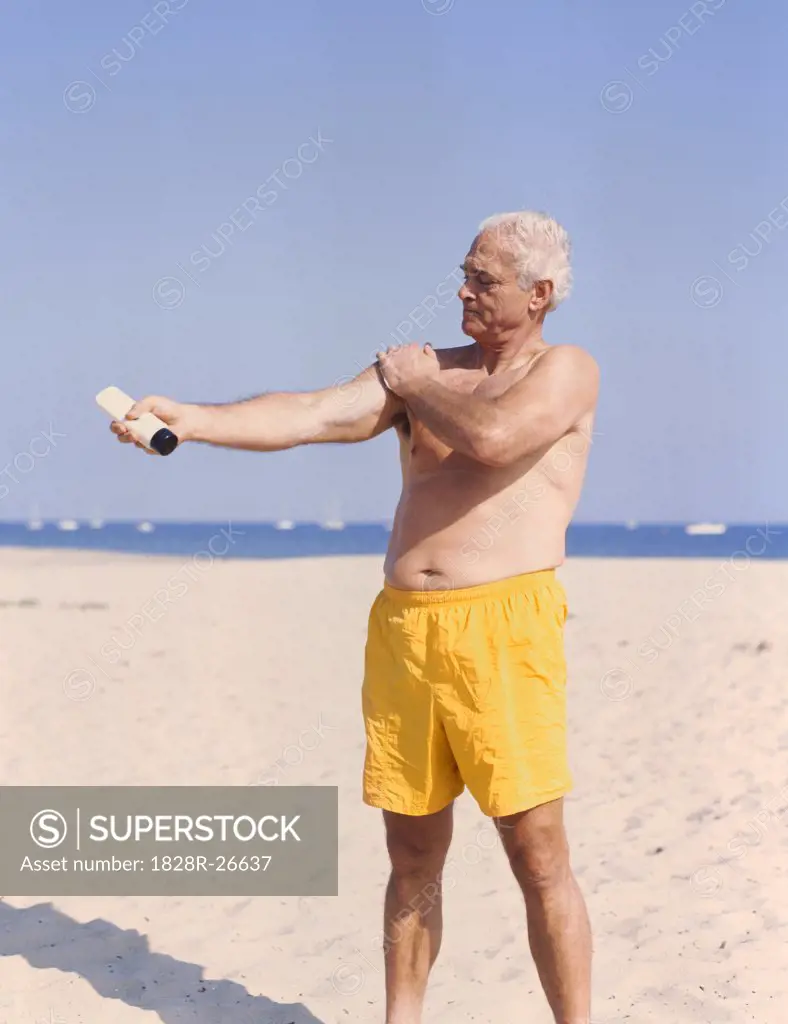 Man on Beach Applying Sunscreen   
