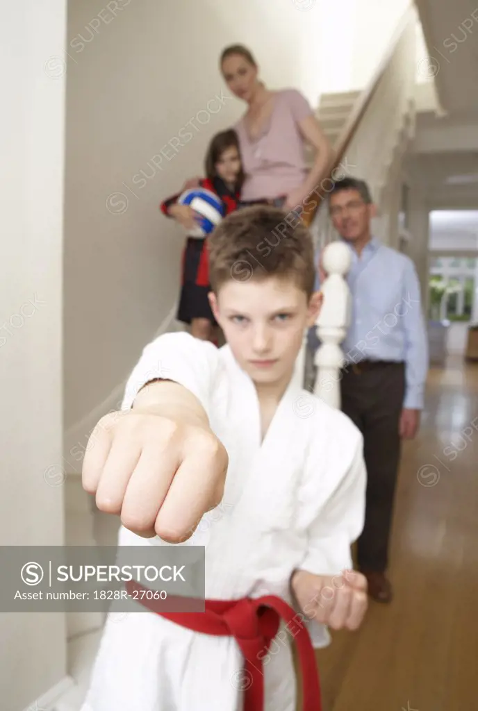 Boy in Karate Gi With Family in Background   