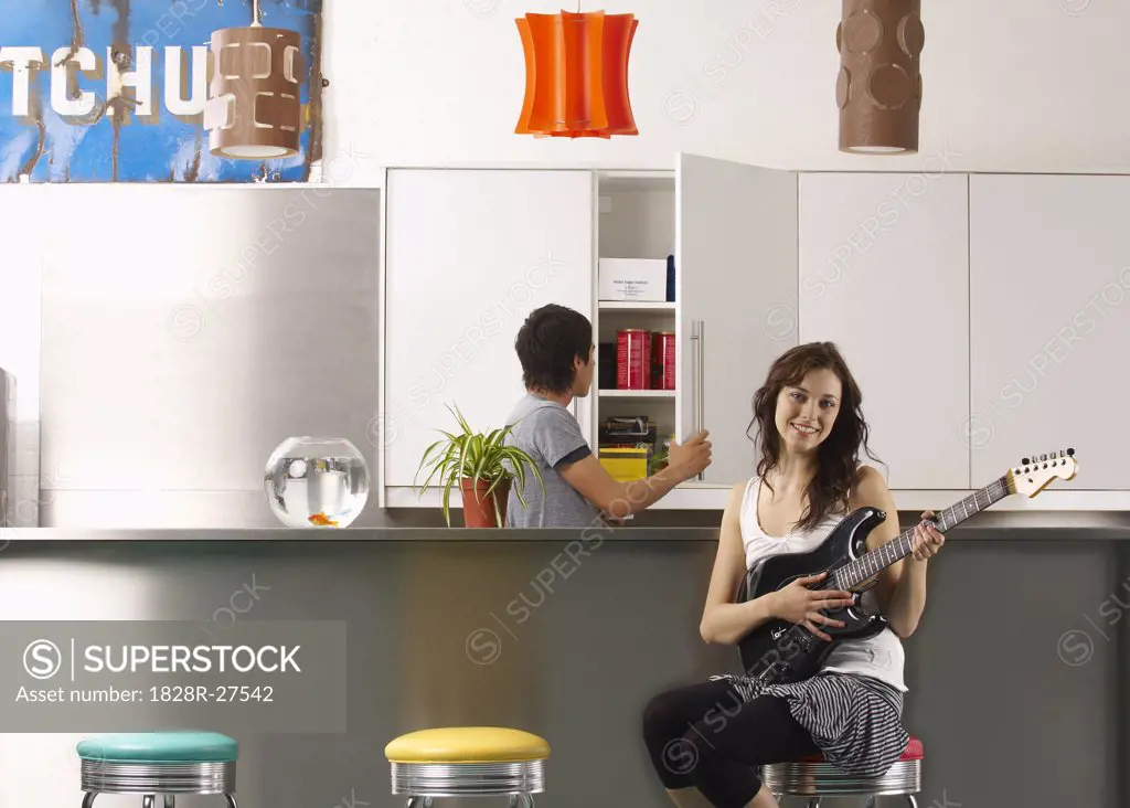 Woman and Man in Kitchen with Electric Guitar   