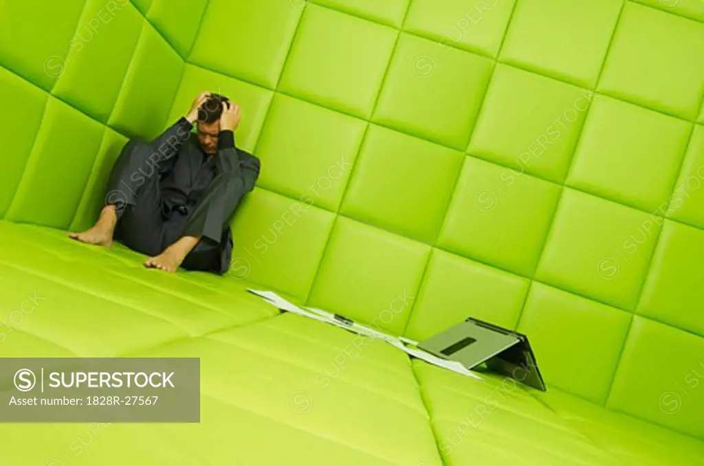Man with Laptop and Paperwork in Padded Room   