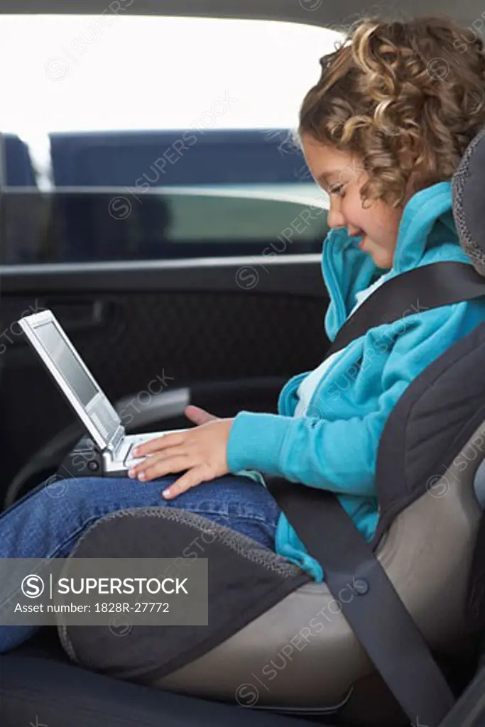 Girl with DVD Player, Sitting in Back Seat of Car   