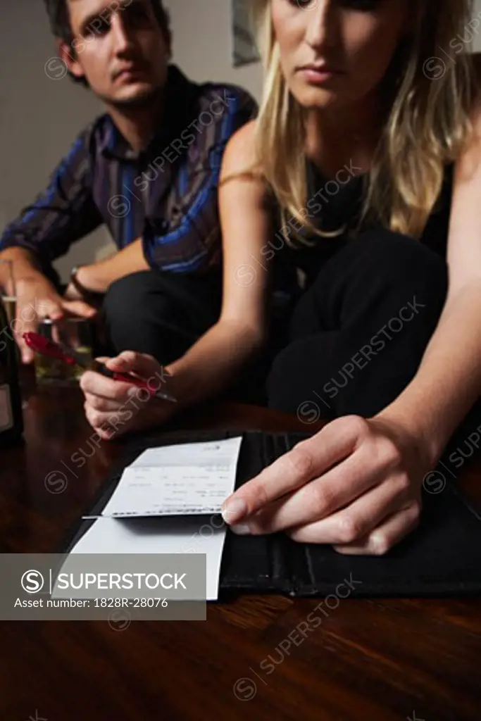Woman Signing Bill at Bar   