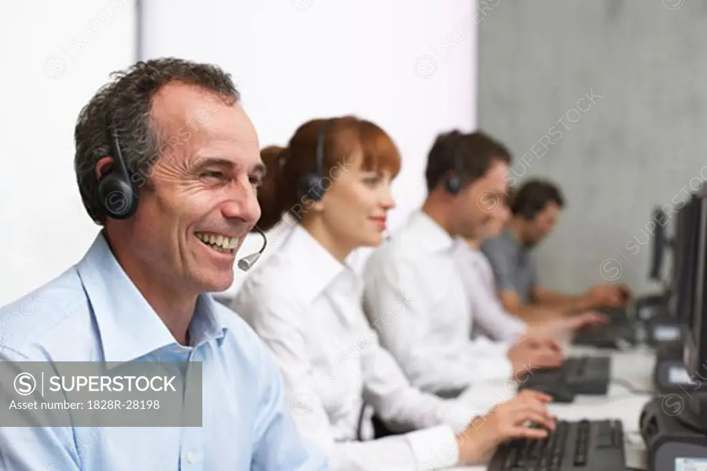 Business People Working at Computers with Headsets   