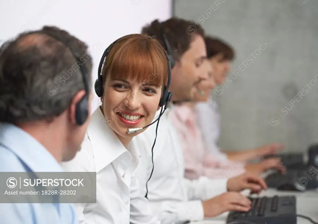 Business People Working at Computers with Headsets   