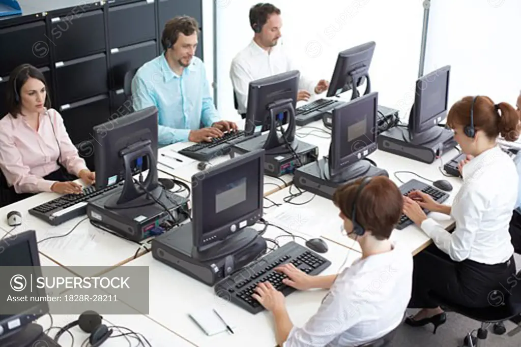 Business People Working on Computers with Headsets   