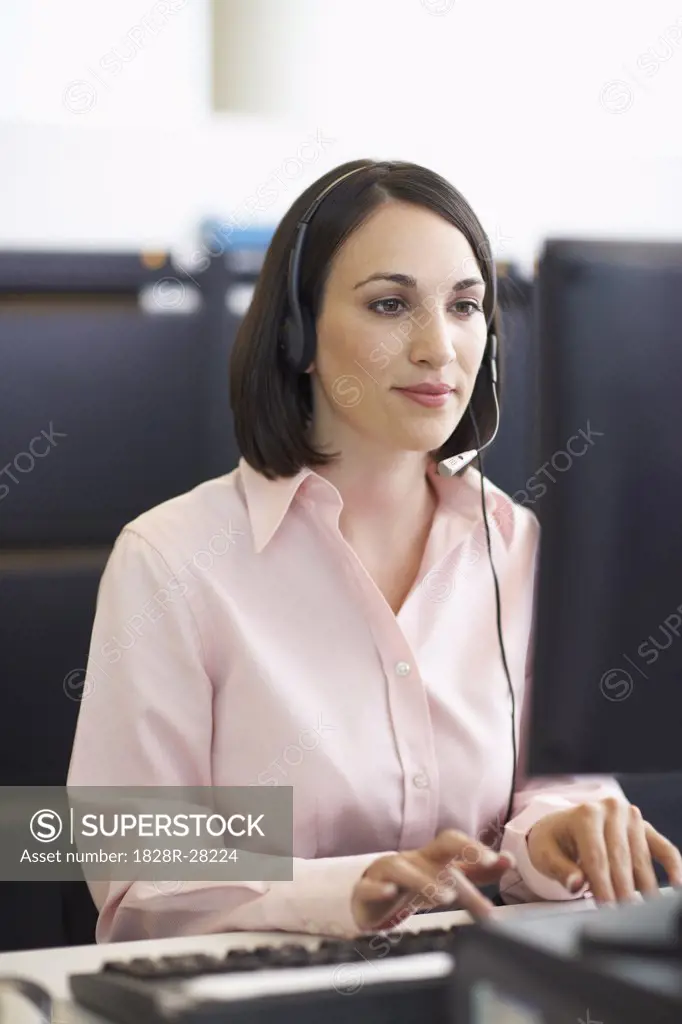 Businesswoman Working on Computer with Headset   