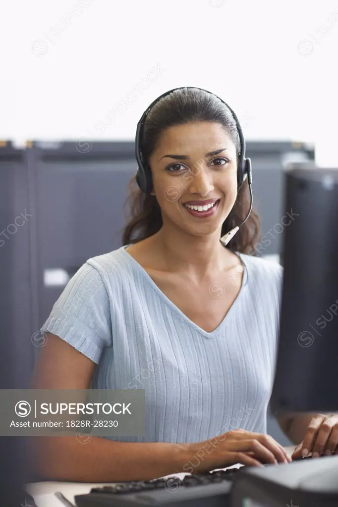 Businesswoman Working on Computer with Headset   