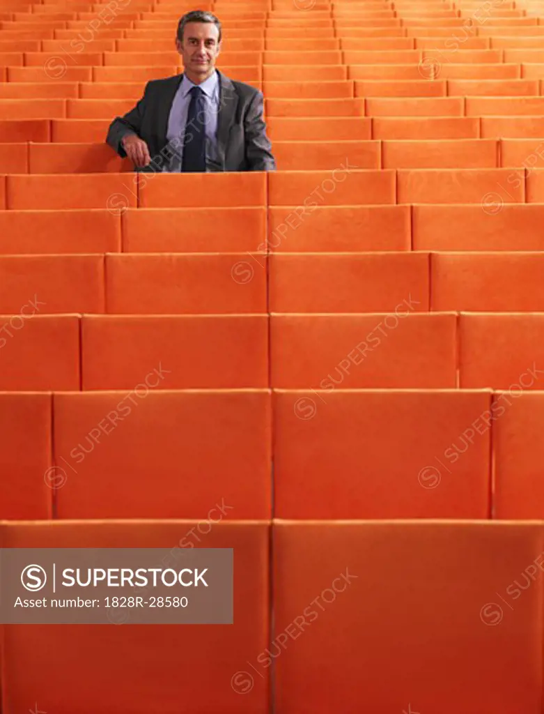 Businessman Sitting in Auditorium   