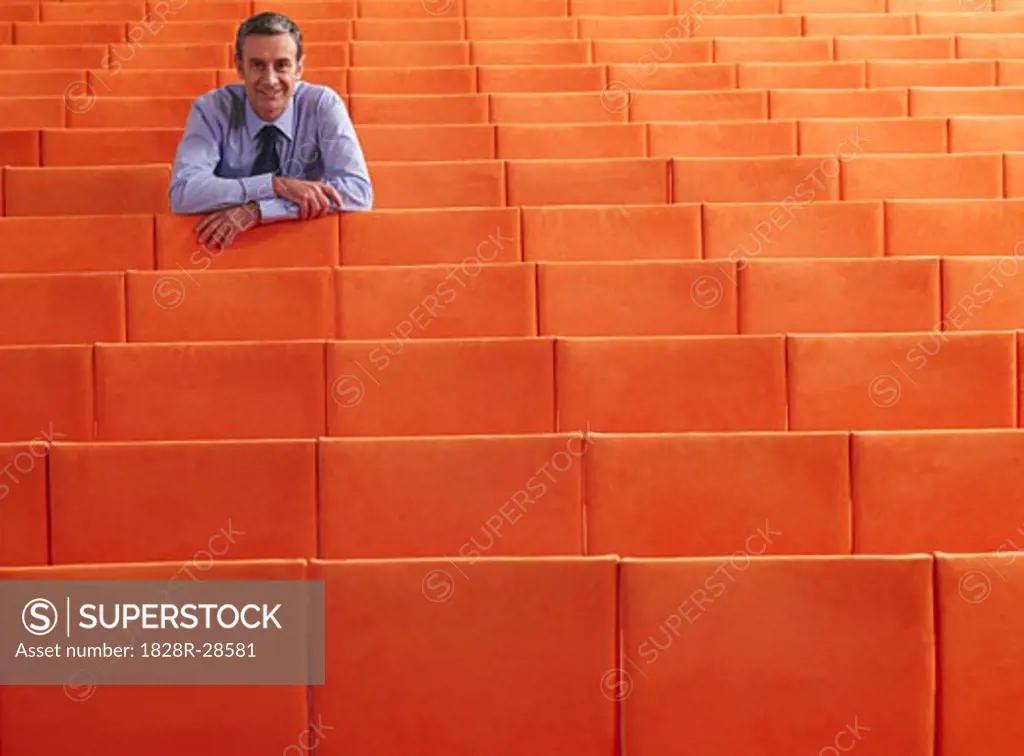 Businessman Sitting in Auditorium   