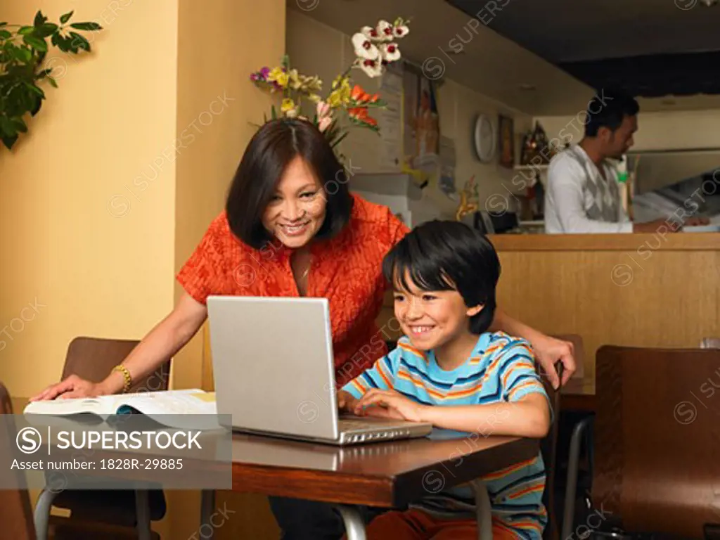 Boy and Mother with Homework in Restaurant   