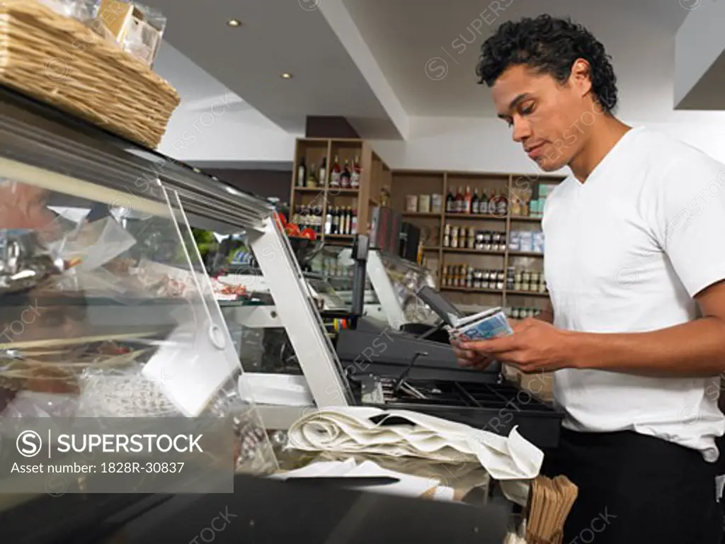Man Counting Cash at Register   