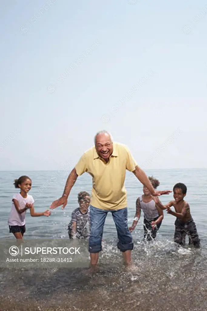 Man Being Splashed by Children in Lake   