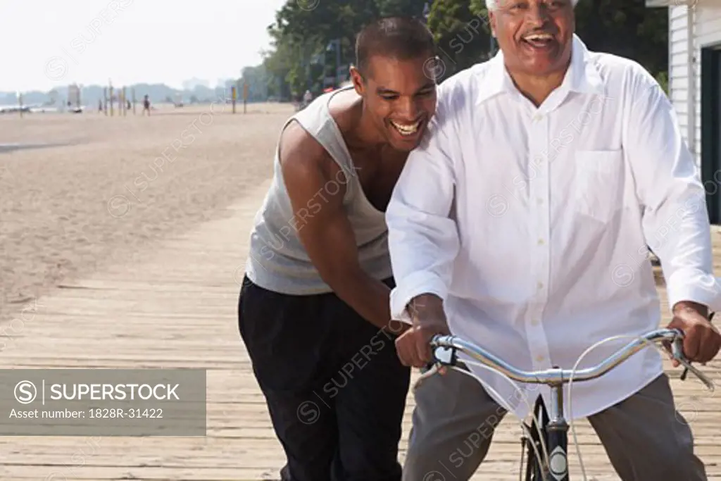 Son Pushing Father on Bicycle   