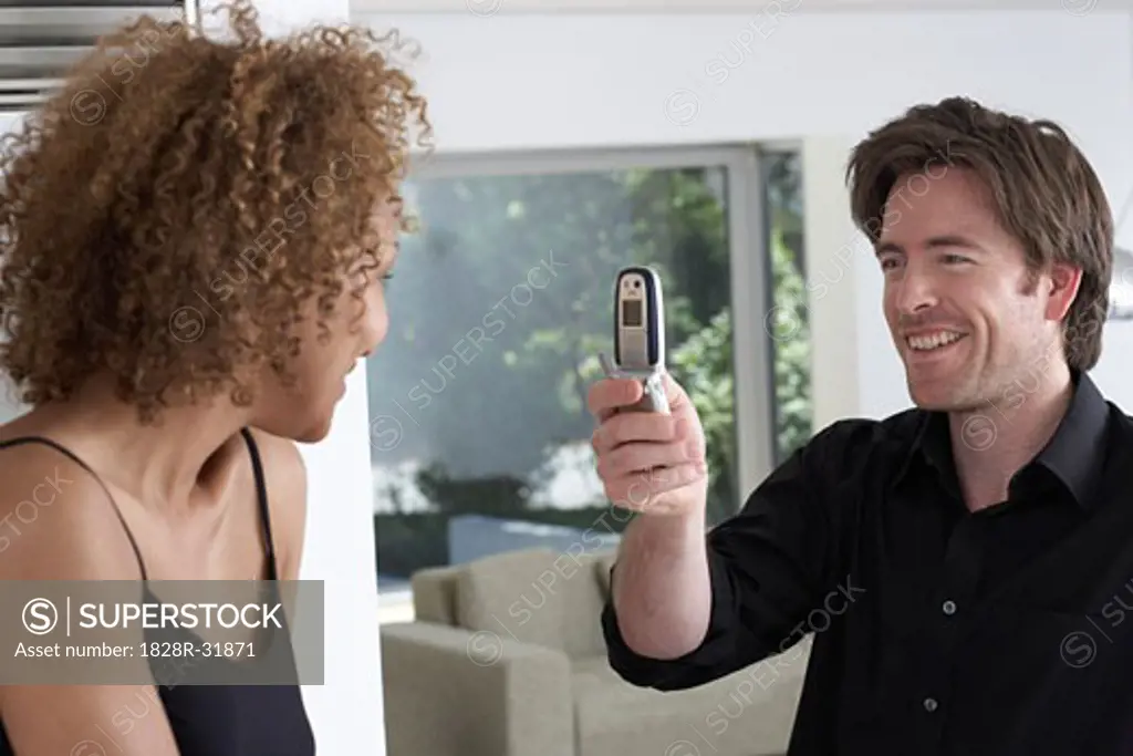 Man Taking Picture of Woman With Camera Phone   