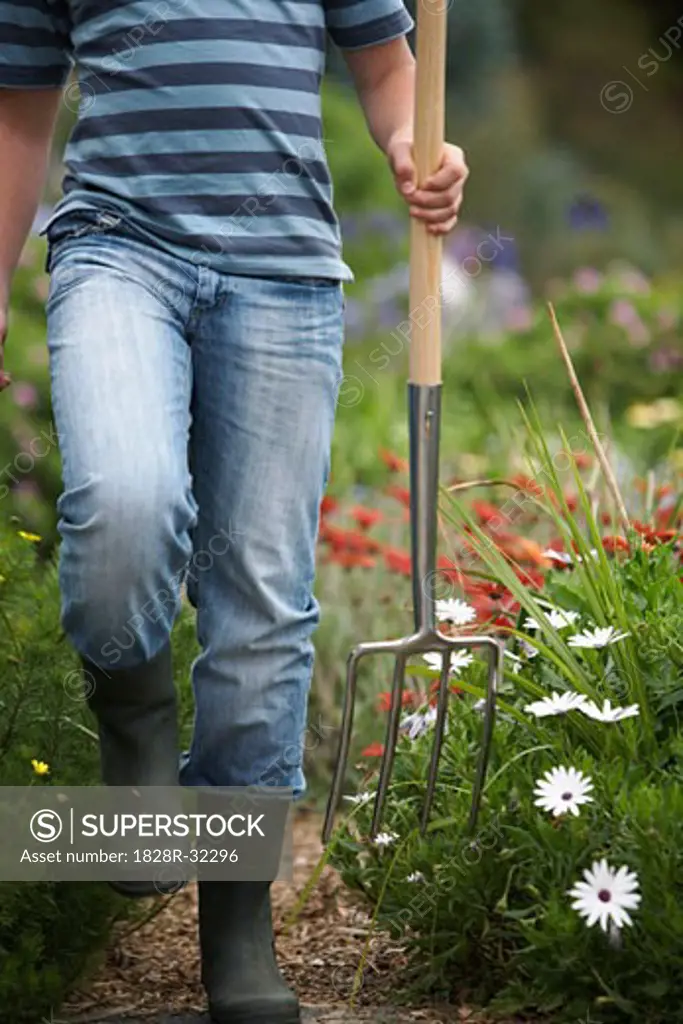 Teenage Boy Carrying Gardening Fork   