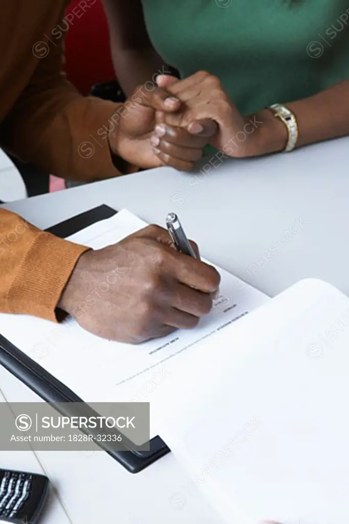 Close-up of Couple Signing Papers   