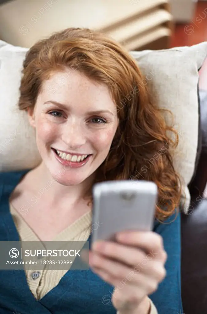 Woman with Electronic Organizer on Sofa   