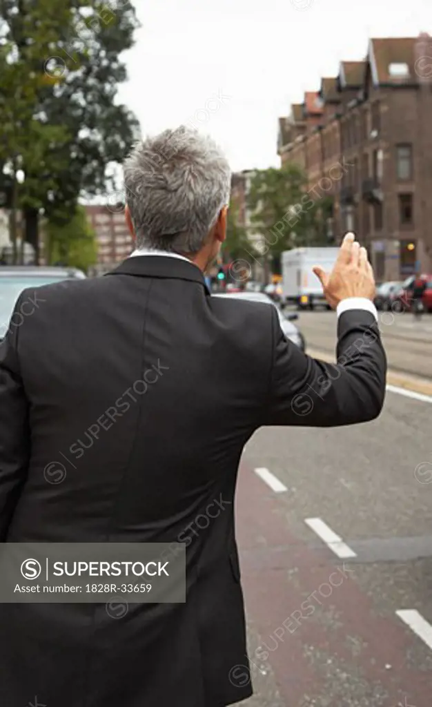Businessman Hailing Cab, Amsterdam, Netherlands   