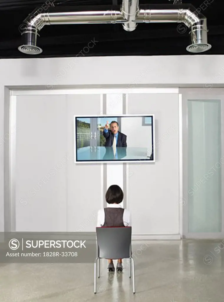 Businesswoman Videoconferencing with Big Screen Television   