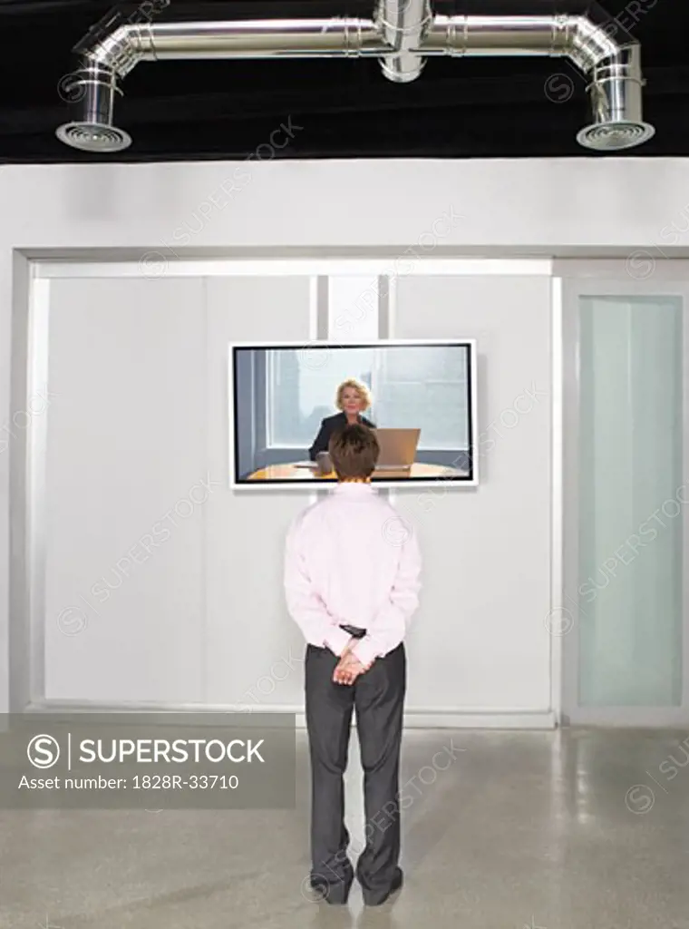 Businessman Videoconferencing with Big Screen Television   