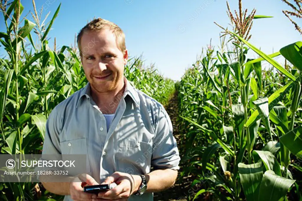 Farmer in Cornfield with Electronic Organizer   