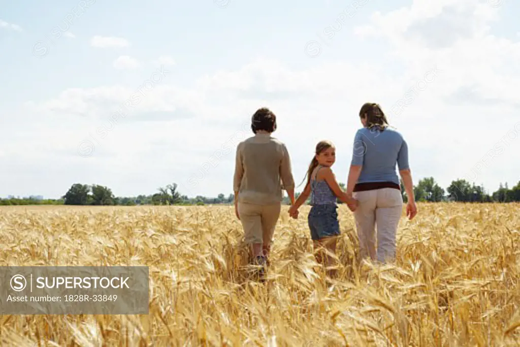 Grandmother, Mother and Daughter Walking in Grain Field   