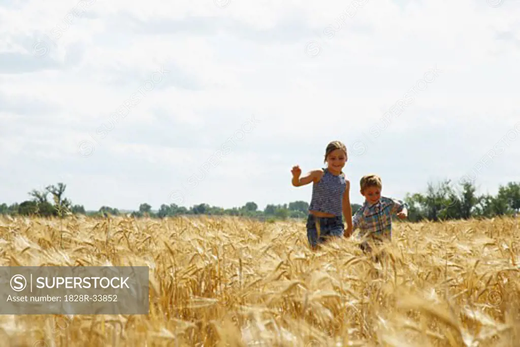 Brother and Sister Running through Grain Field   