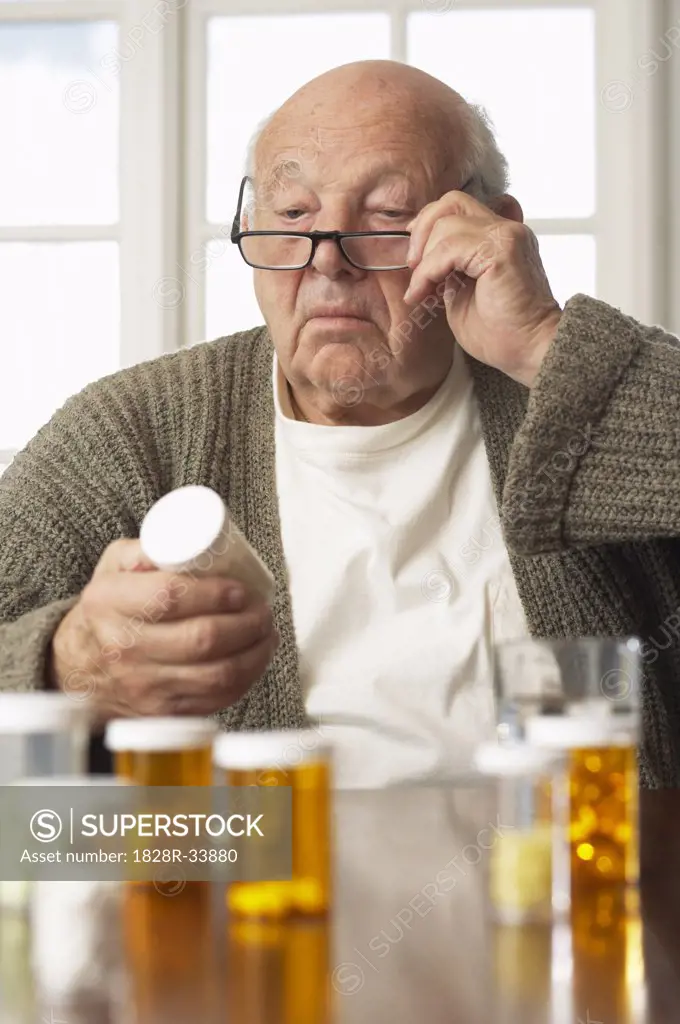 Senior Man Looking at Pill Bottle Label   