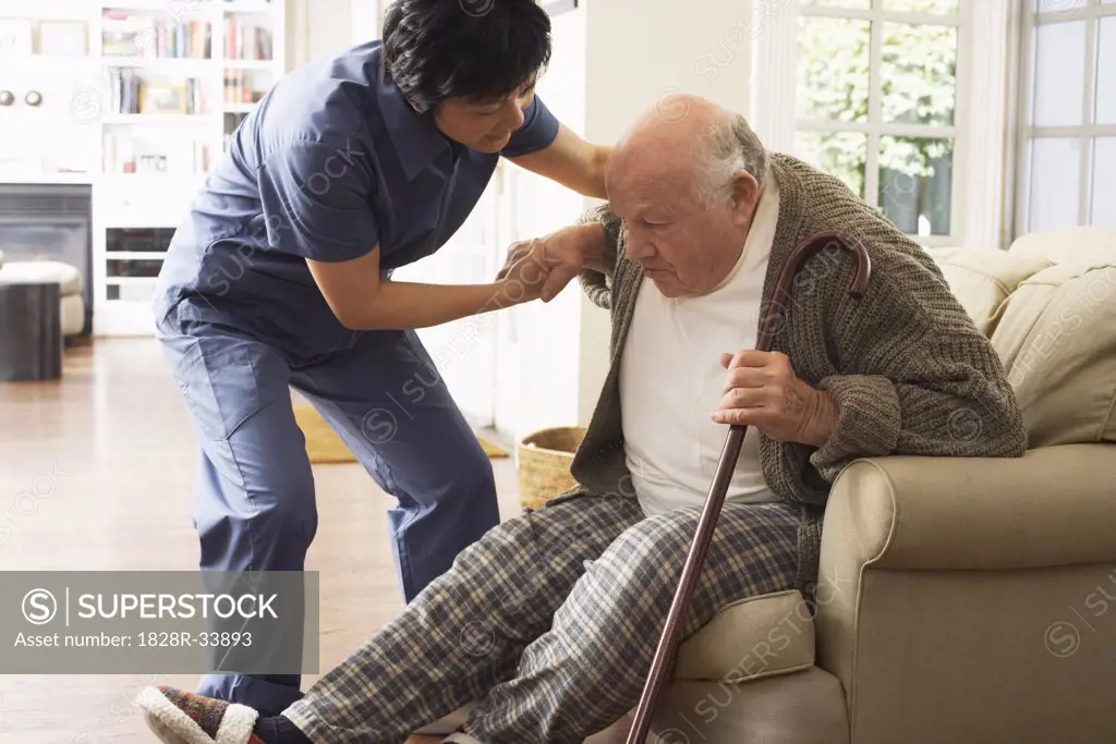 Senior Man Receiving Assistance Getting out of Chair   