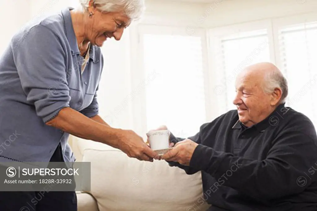 Senior Woman Serving Senior Man Beverage   