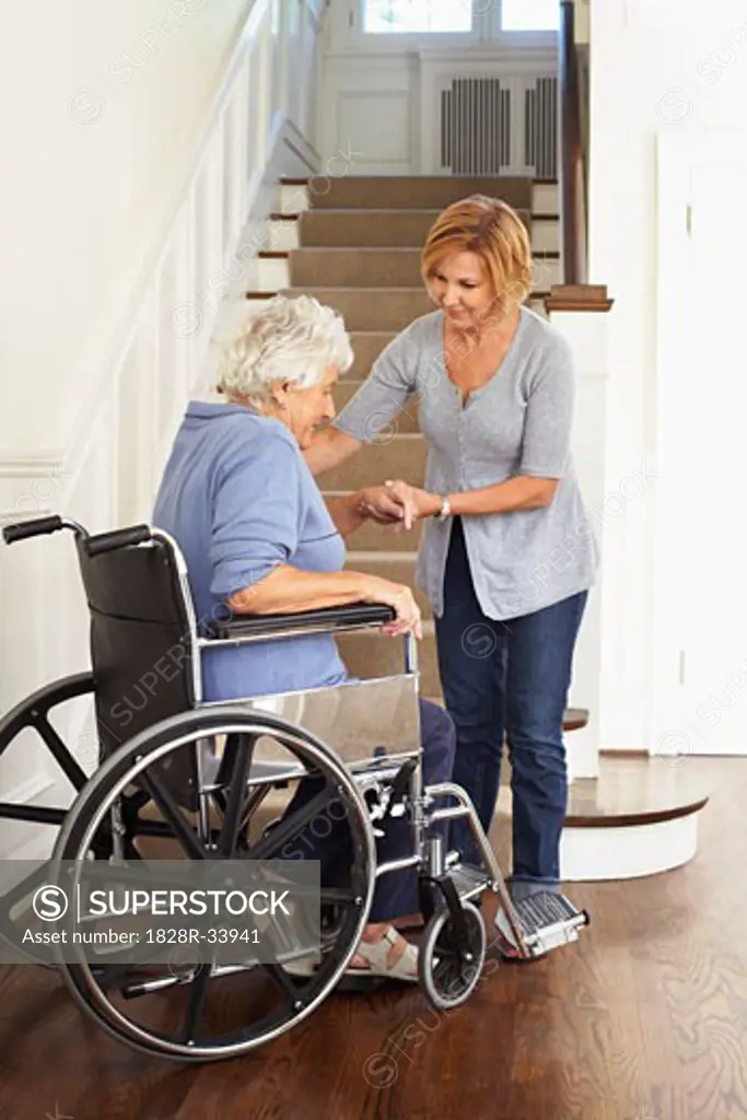 Senior Woman in Wheelchair Receiving Assistance   