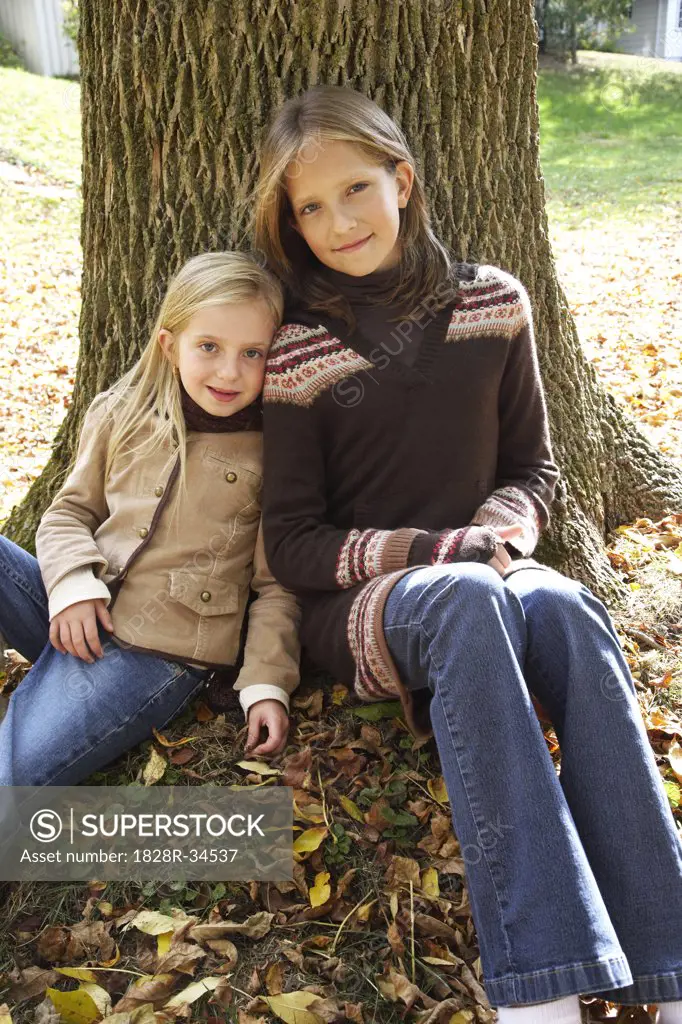 Portrait of Girls Sitting in Front of Tree, in Autumn   