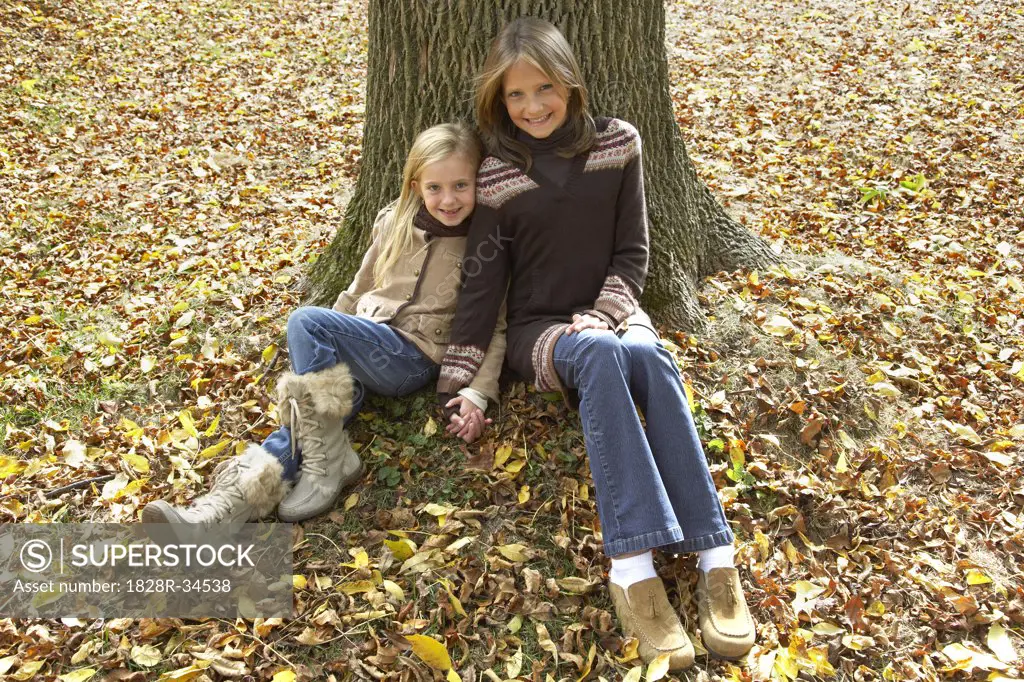Portrait of Girls Sitting in Front of Tree, in Autumn   