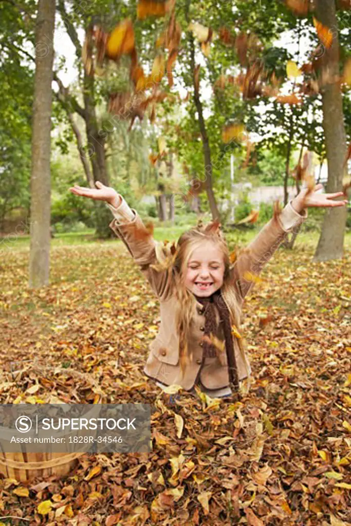 Girl Throwing Autumn Leaves in Air   