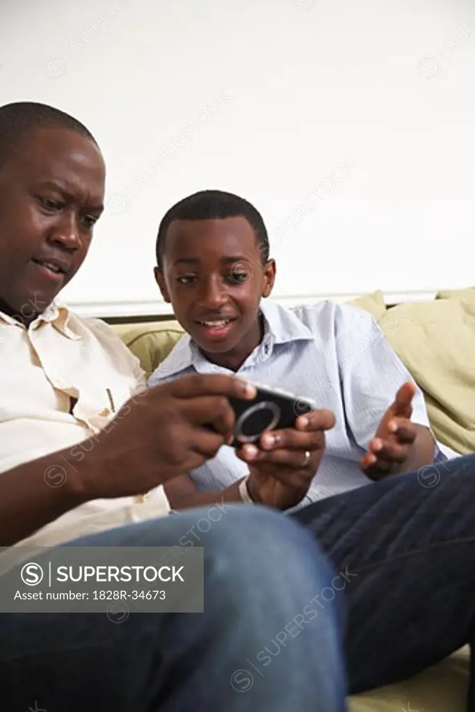 Father and Son with Hand-Held Video Game   