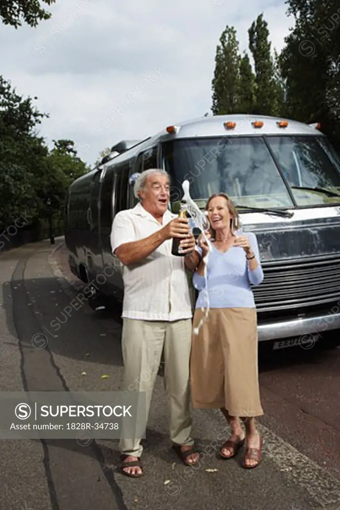 Couple Standing by Trailer, Celebrating With Champagne   