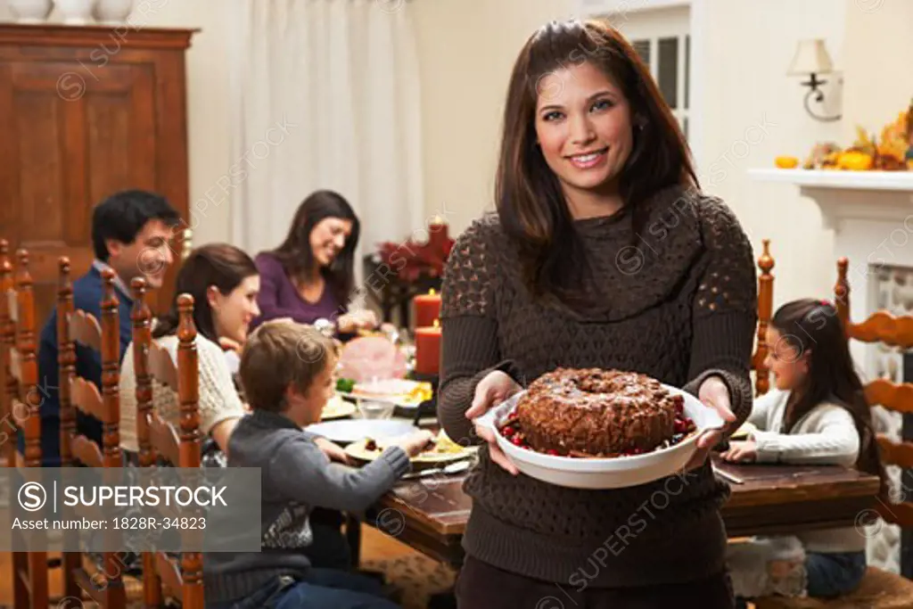 Woman Holding Dessert at Family Dinner   