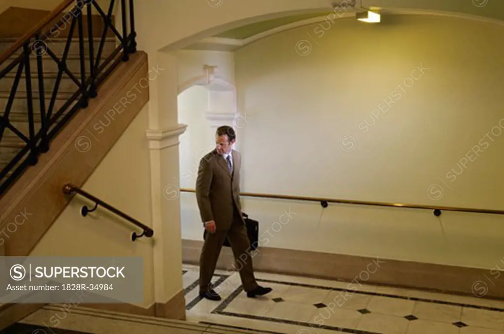 Businessman Walking in Hallway   