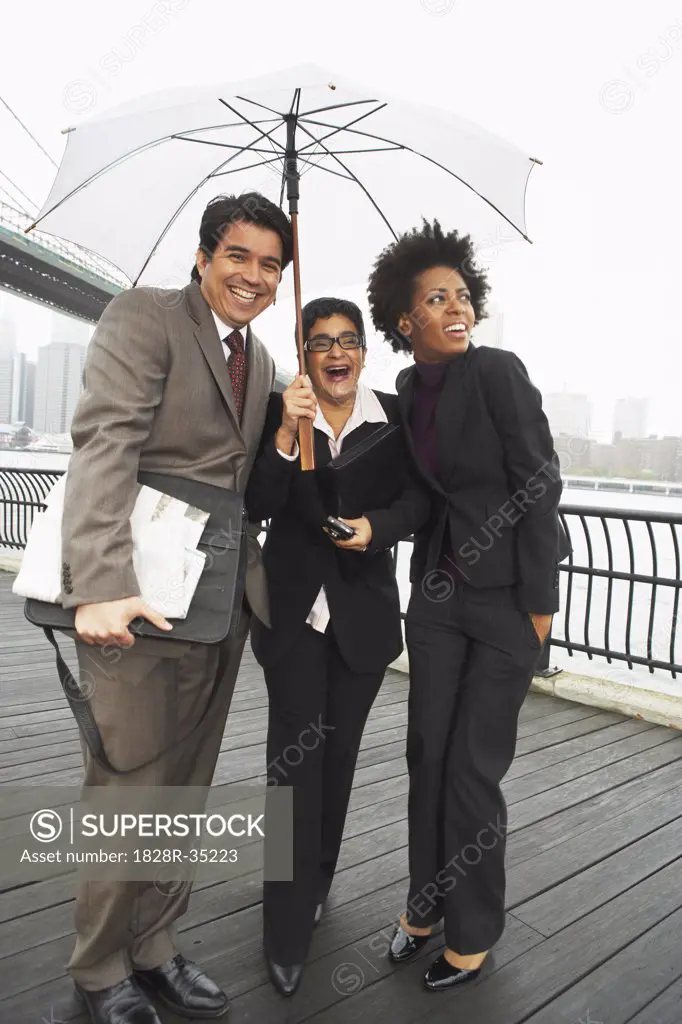 Business People Under Umbrella by East River, New York City, New York, USA   