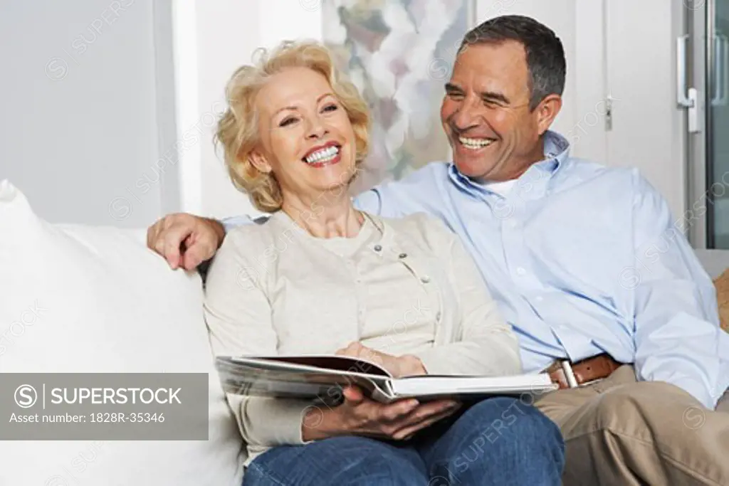 Couple with Book on Sofa   